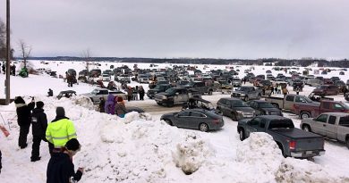 A photo of a whole bunch of cars on a lake.