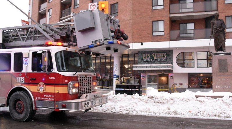 A fire truck is parked in front of a hotel.
