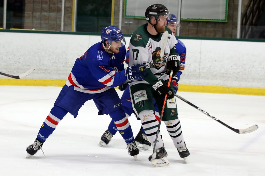 Two hockey players battle in front of the net.