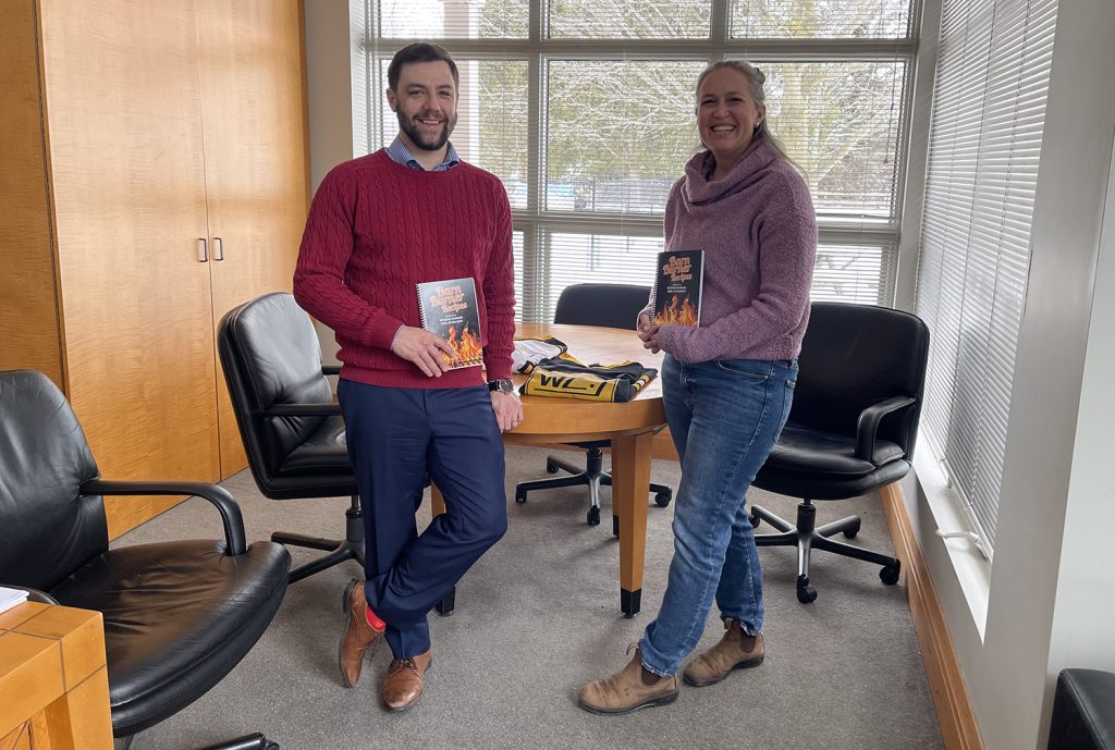 Two people hold books.