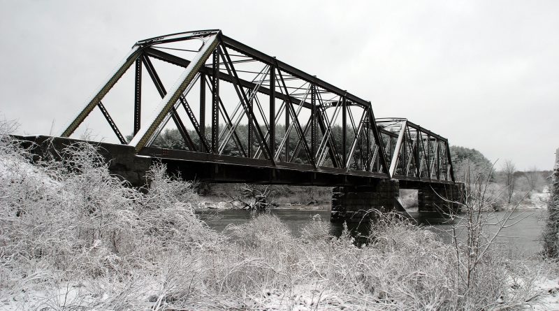 A photo of a snowy rail bridge.