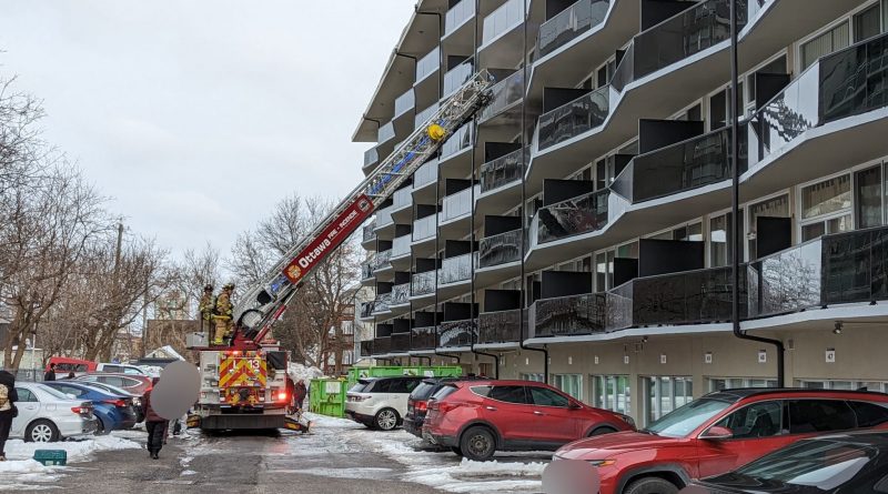 A photo of a fire truck outside an apartment building.