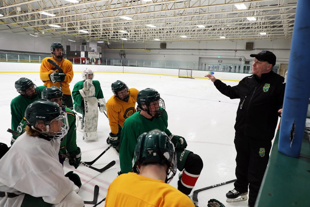 a photo of a coach coaching his hockey team.