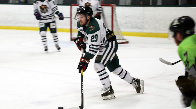 A photo of a hockey player skating with the puck.