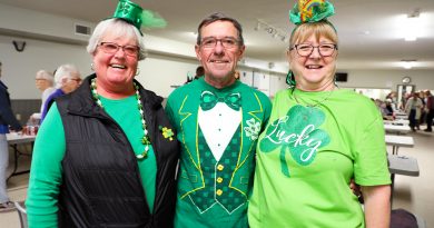 Three people dressed for St. Pat's pose for a photo.