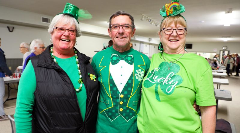 Three people dressed for St. Pat's pose for a photo.