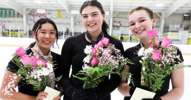 Three figure skaters holding bouqets.