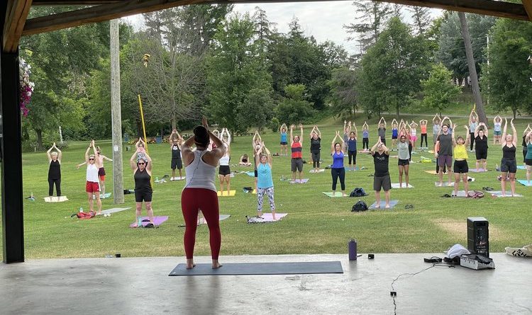 A photo of a yoga class in a park.