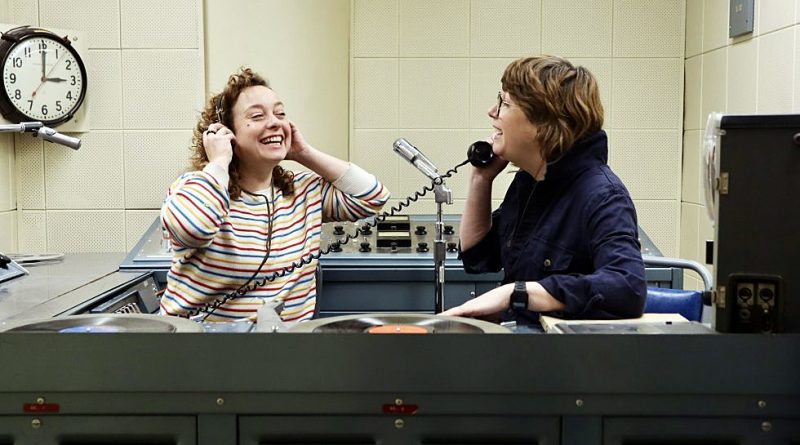 A photo of two people in a radio studio.