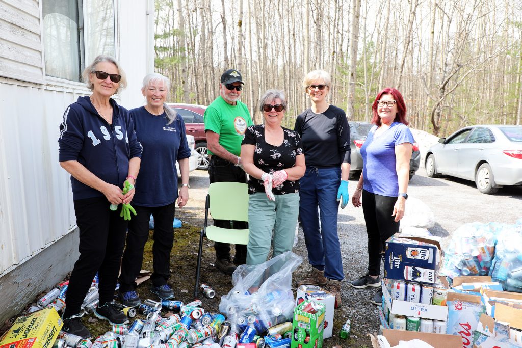 Volunteers pose with a bunch of cans.