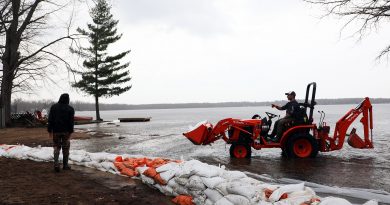 A tractor drives through the Ottawa River delivering sandbags.