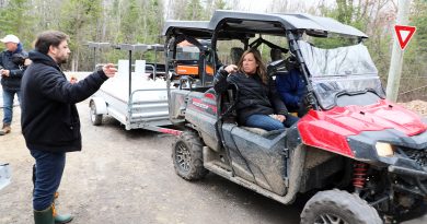 A person talks to people in an ATV.