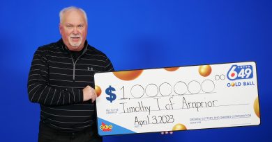 A photo of a man holding a big cheque.