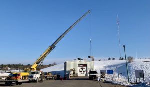 A photo of a crane lifting an HVAC unit.