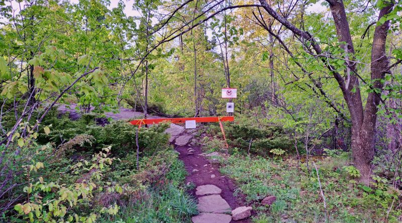 A photo of a barricade across a trail.
