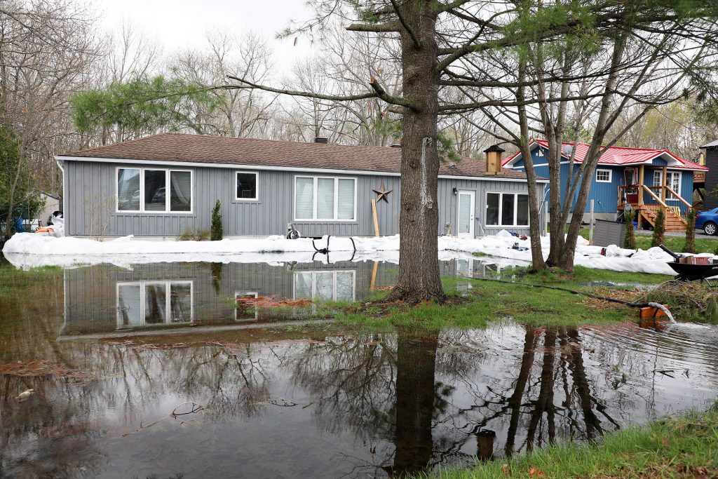 A photo of a house with lots of water around its yard.