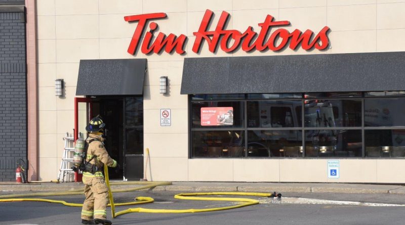 A firefighter approaches a Tim Hortons restaurant.