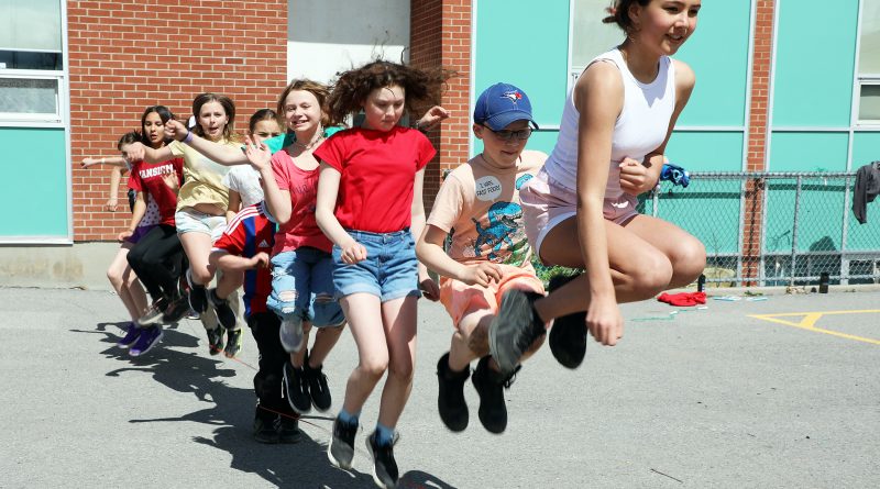 A photo of several kids jumping the same rope.