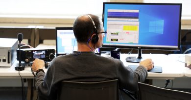 A man operates a radio by computer at a desk.