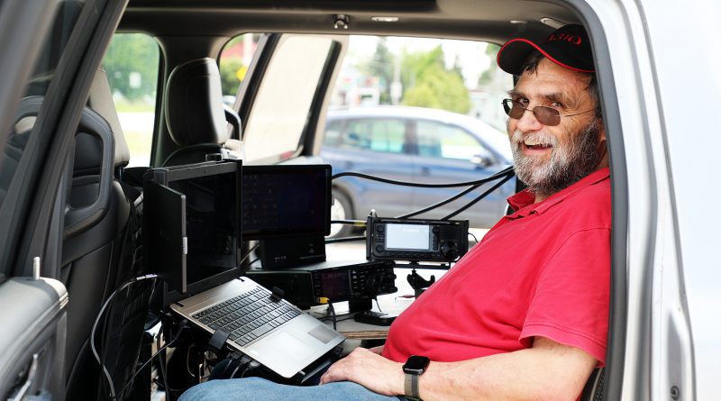 A man sits in his truck outfitted with radio wquipment.