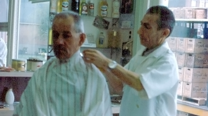 A photo of a barber cutting hair.