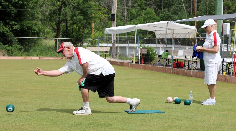 a photo of a person hurling a lawn bowl.