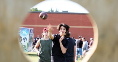 A photo of a student throwing a ball through a hole.