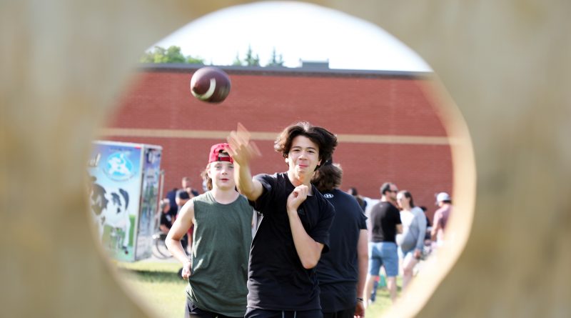 A photo of a student throwing a ball through a hole.