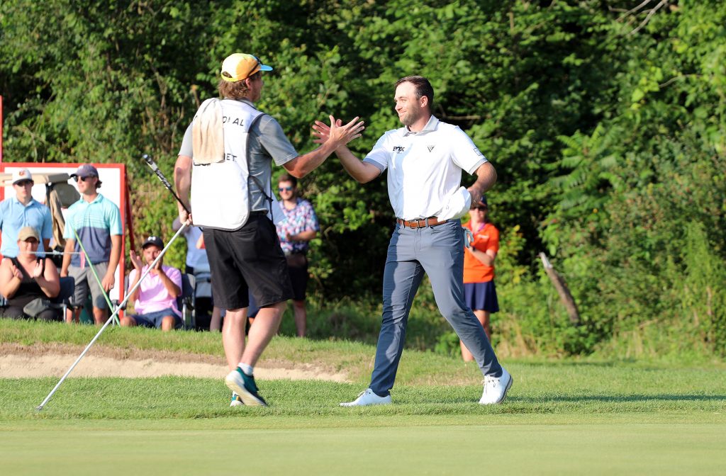 Two men shake hands.