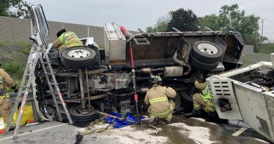 A photo of firefighters working around a crashed vehicle.