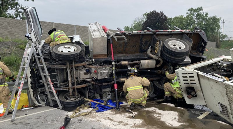 A photo of firefighters working around a crashed vehicle.