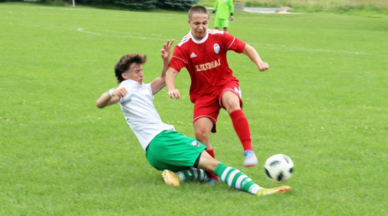 A soccer player performs a slide tackle.