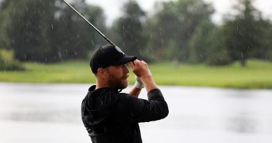 A hockey player watches his golf shot.