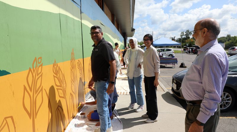 A group of people work on a mural in Dunrobin.