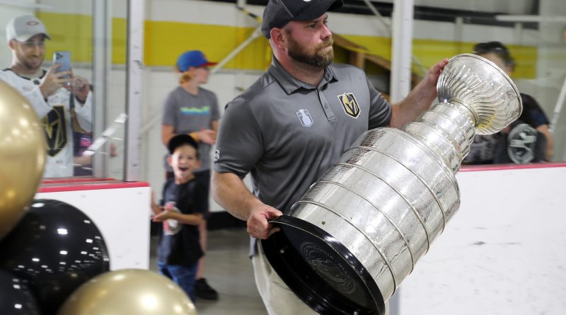 A man carries the Stanley Cup.