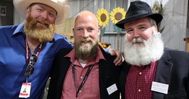 Three bearded men pose for a photo.
