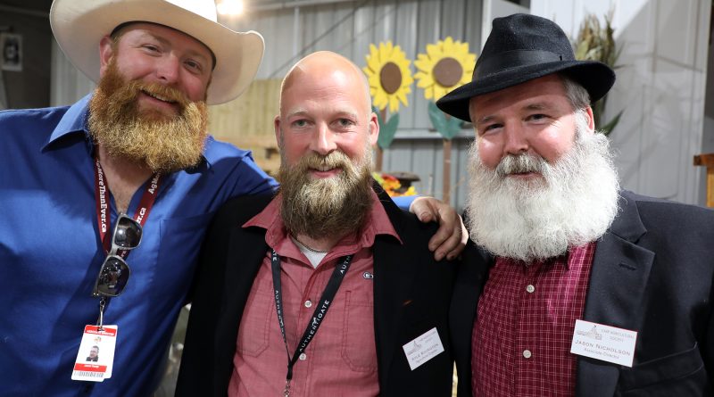 Three bearded men pose for a photo.
