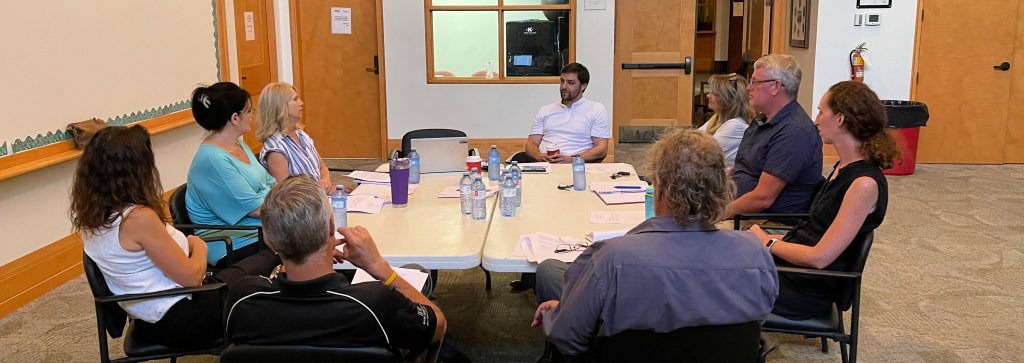 A group of people talk around a table.