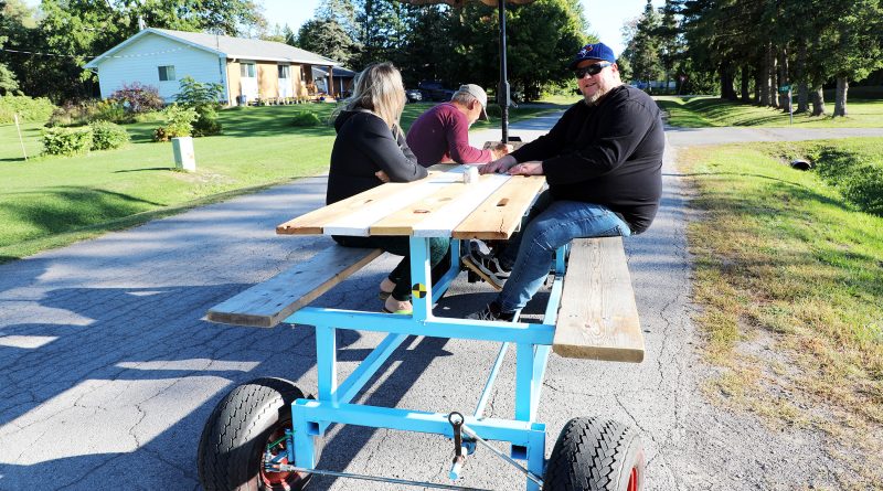 A photo of a picnic table with wheels.