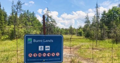 A photo of a sign and the Burnt Lands Alvar.