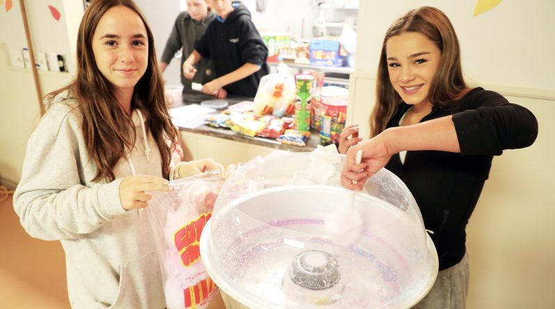 Two young volunteers make candy floss.