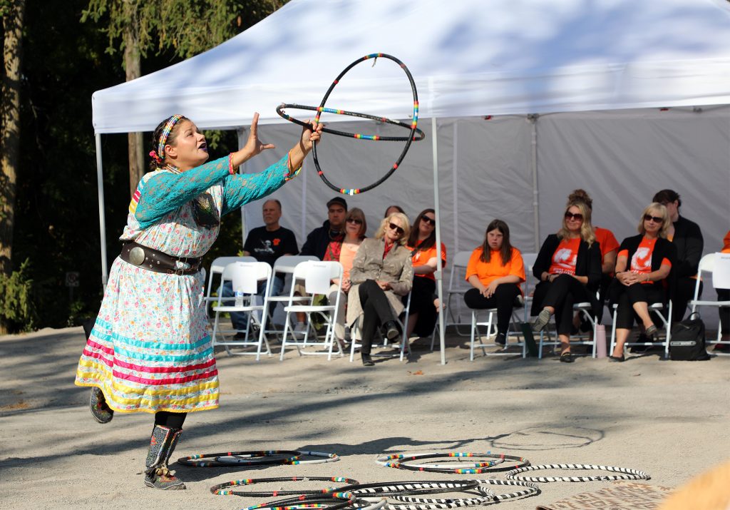 A woman performs a hoop dance.