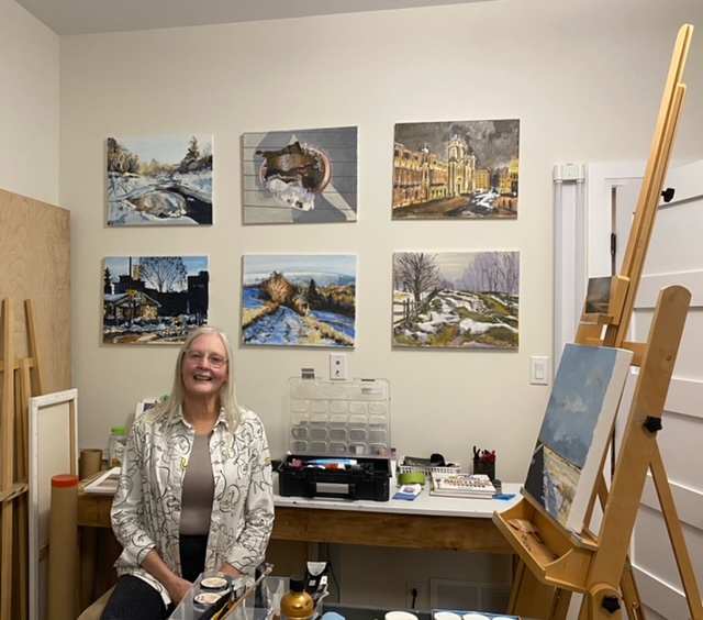 A woman poses in an art studio.