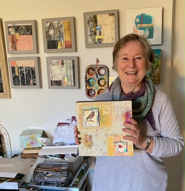 A woman poses with a painting.