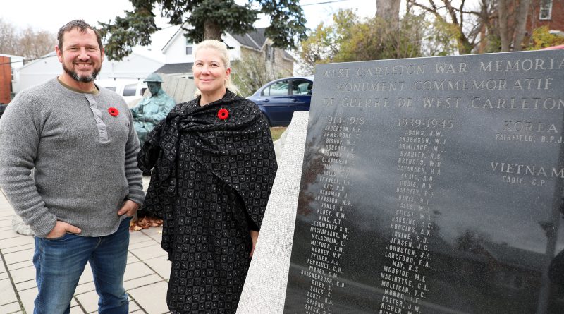 Two people pose at the West Carleton War Memorial.