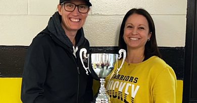 Two people pose with a trophy.