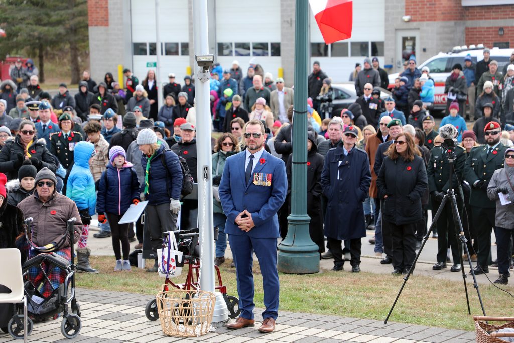 A man stands by a flag pole.