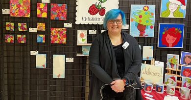 An artist poses in front of her work.