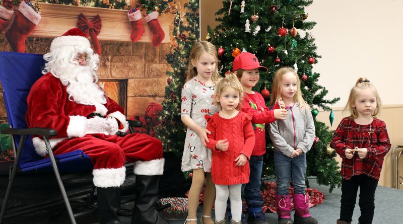 A group of kids pose with Santa.