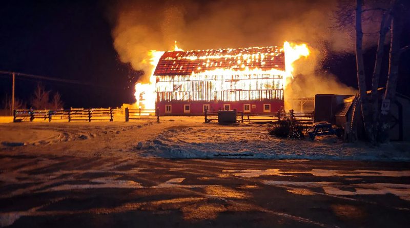 A photo of a barn on fire.